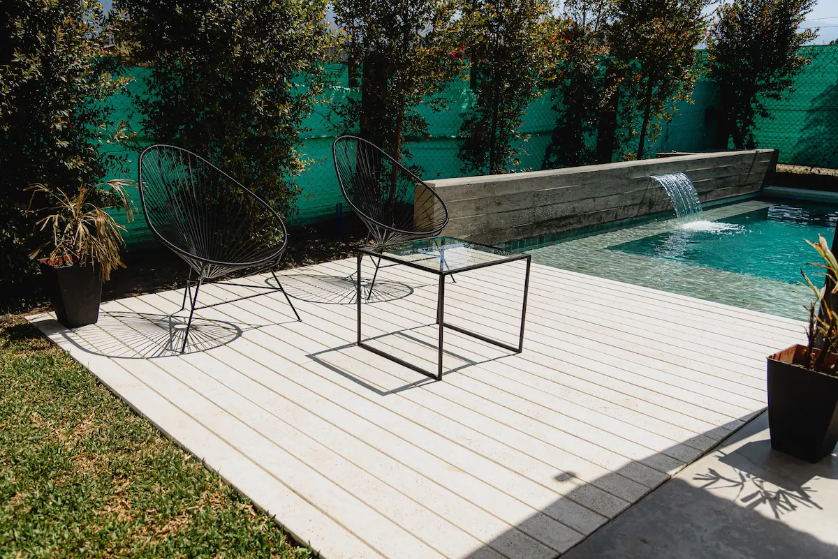 Pileta con revestimiento Piedra Bali, cascada y deck WPC — Barrio Privado Divisadero, Yerba Buena, Tucumán