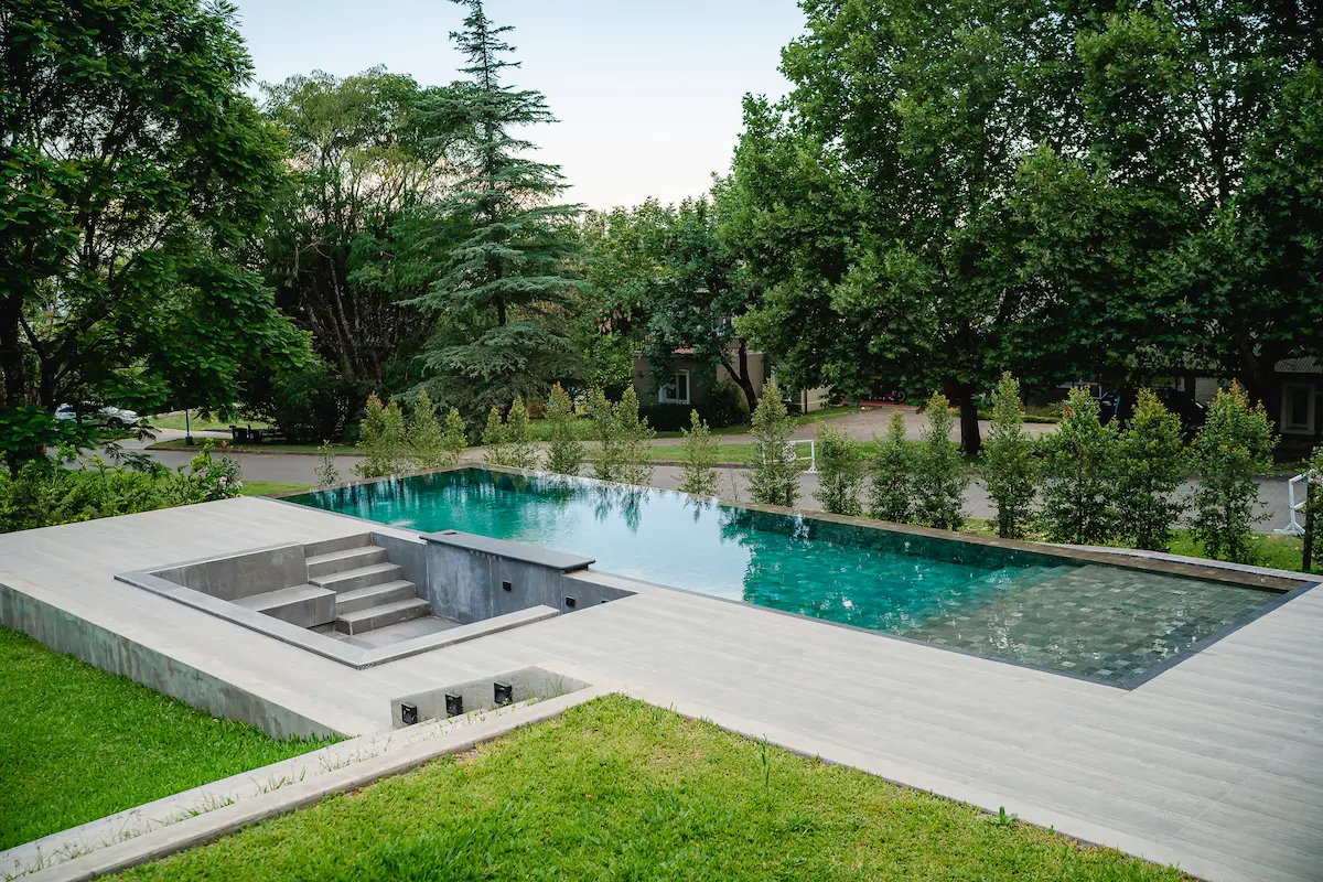 Pileta infinita con fogonero integrado, solarium y ducha exterior — Las Yungas Golf & Country Club, Yerba Buena, Tucumán